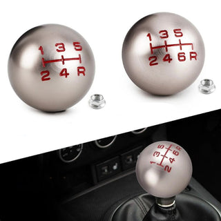 Metallic shift knob with red gear pattern and matching nut
